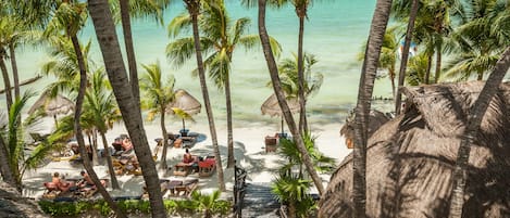 Plage privée, sable blanc, chaises longues, serviettes de plage