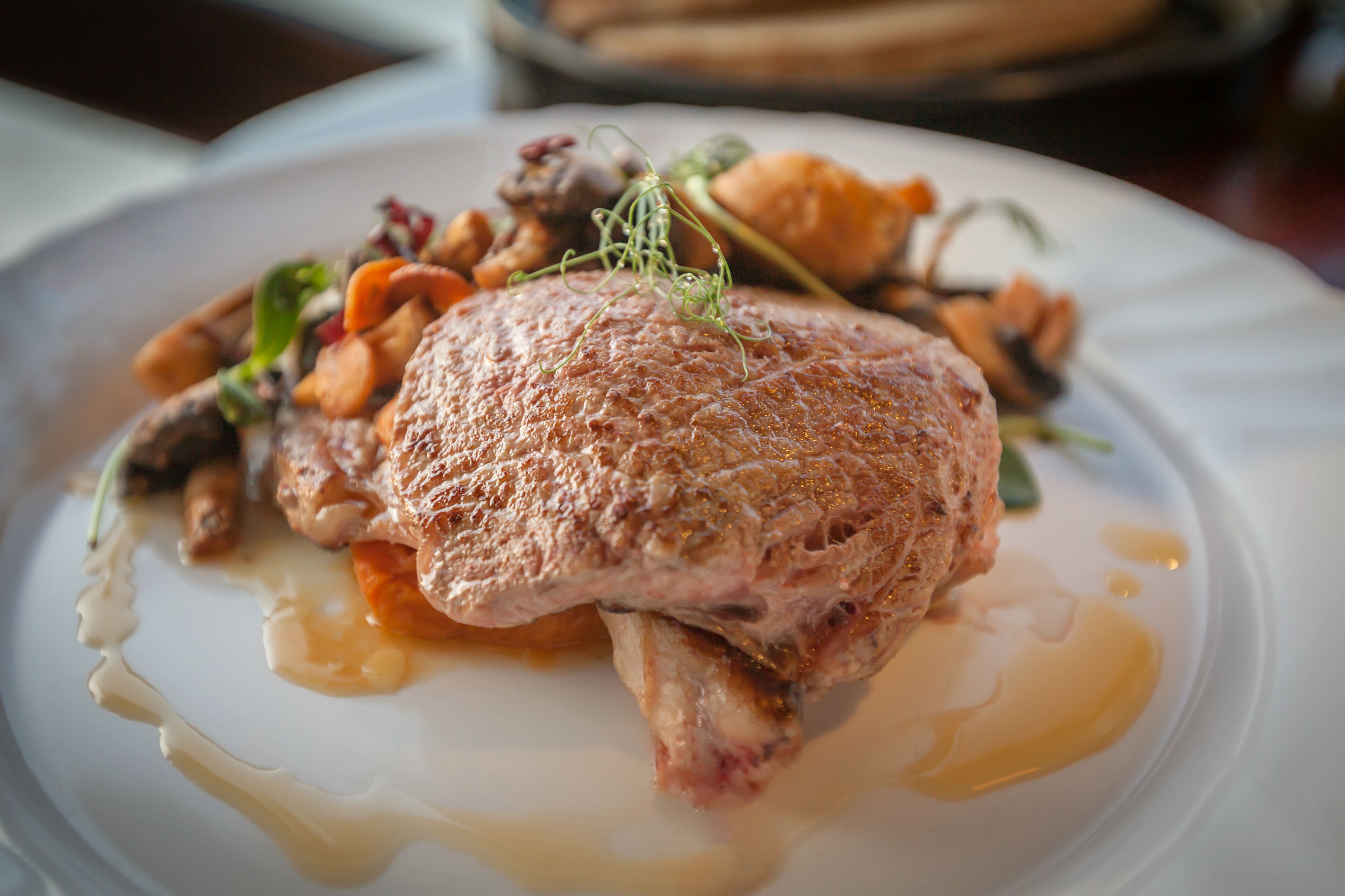 Ein Teller mit Fleisch, Gemüse und Soße.