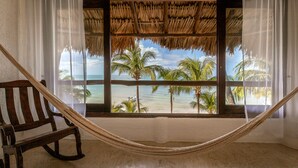 A hammock tied between two windows overlooking a beach with palm trees. - Beachfront Hotel La Palapa - Adults Only (Isla Holbox)
