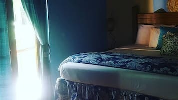 Ein Schlafzimmer mit Bett, Vorhängen und einem Fenster.