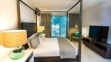 Una habitación de hotel moderna con una cama grande, una televisión, un mueble de televisión y vistas a palmeras a través de la ventana.