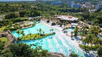 Una vista aerea di un resort con una grande piscina, palme e una spiaggia.