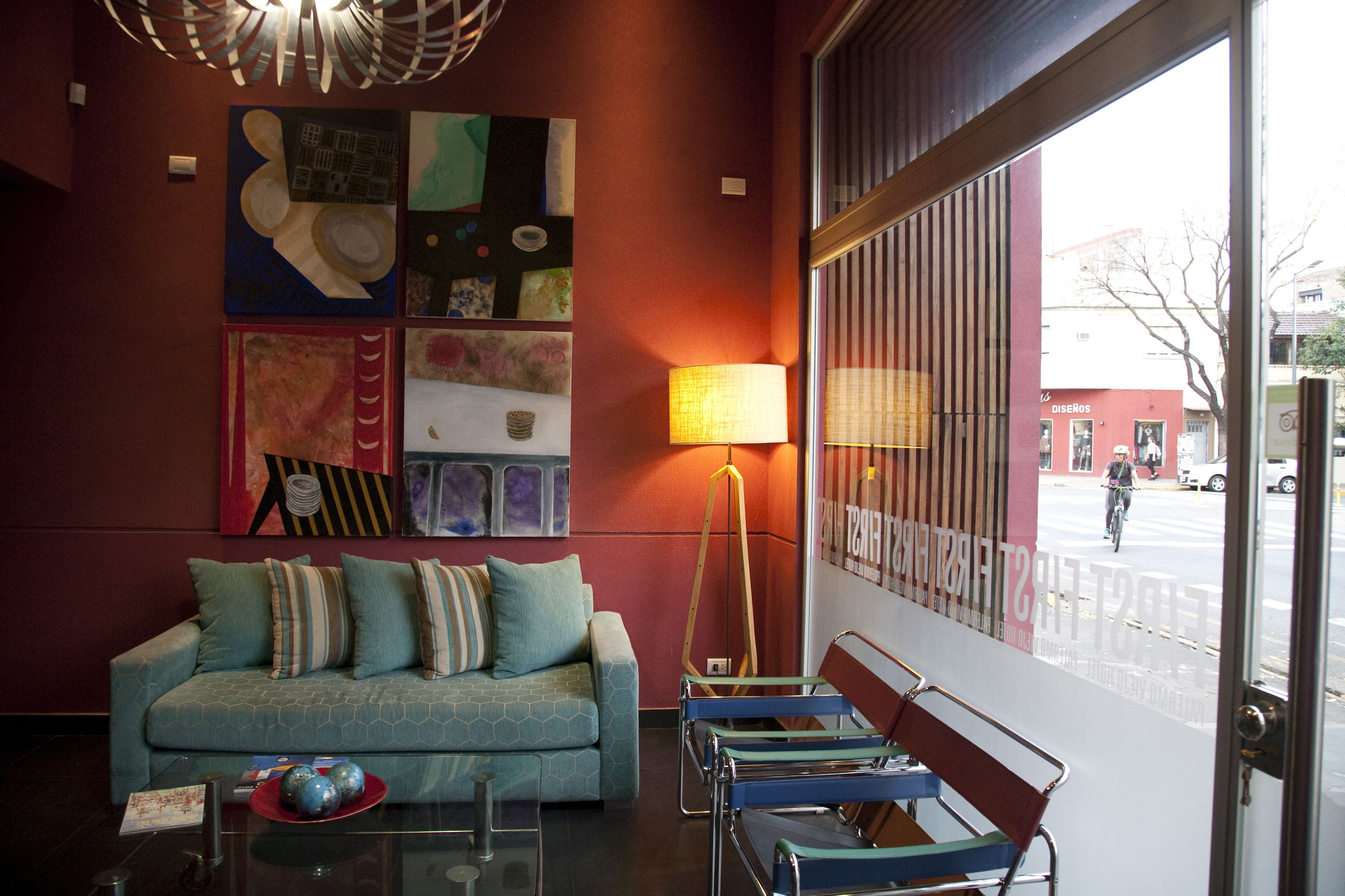 Un interior moderno con un sofá, sillas y arte abstracto en las paredes.