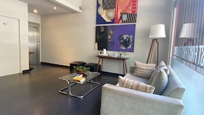 A modern living room with a sofa, coffee table, and artwork on the wall. - First Palermo Viejo Hotel (Buenos Aires)