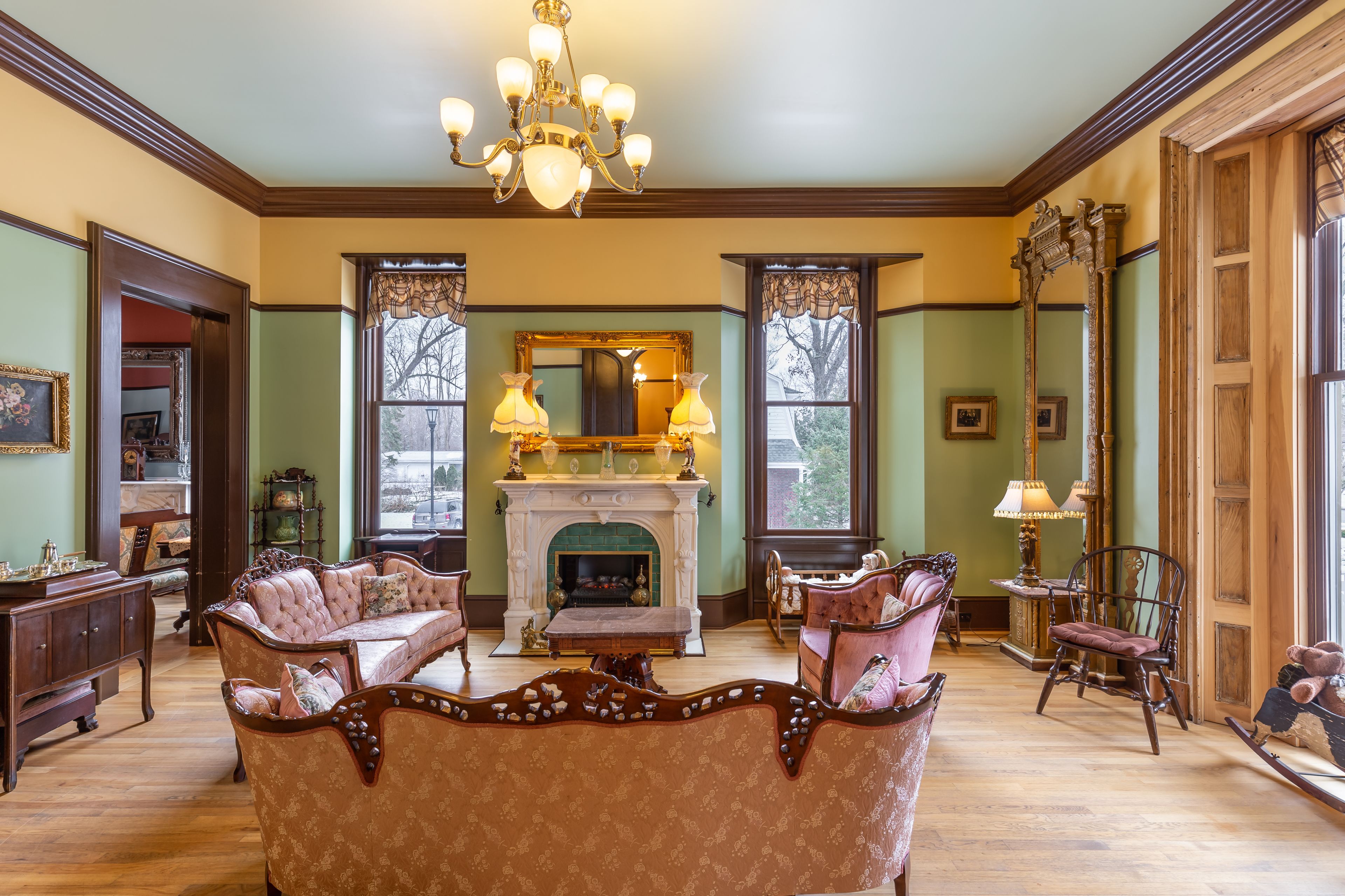 A traditional living room with a fireplace, ornate furniture, and a chandelier.