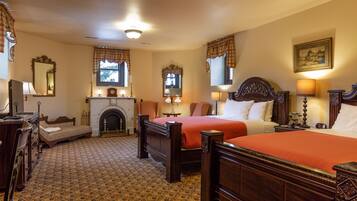 A traditional hotel room with two wooden beds, a fireplace, and classic decor.