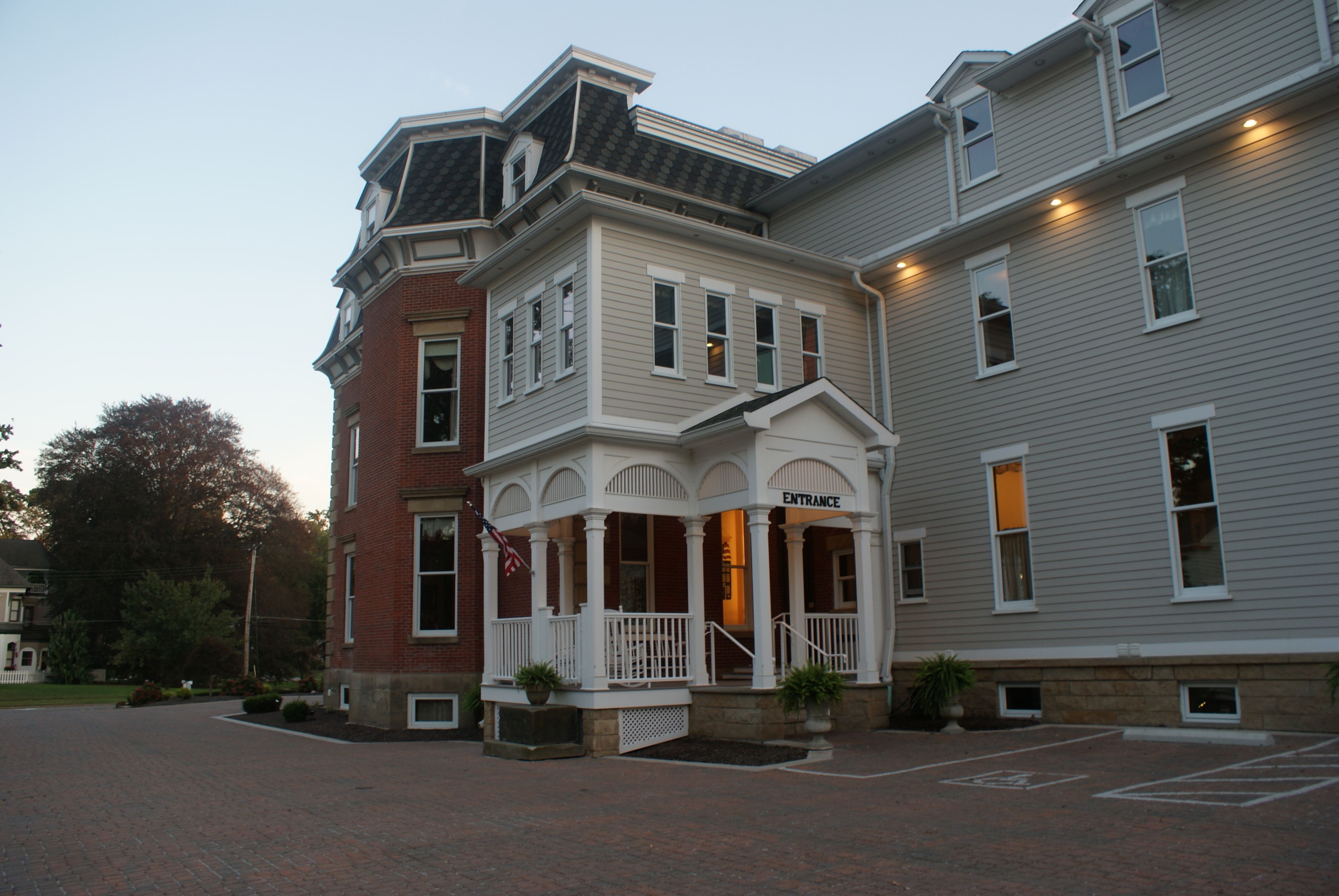 A two-story building with a prominent entrance and a covered porch area.