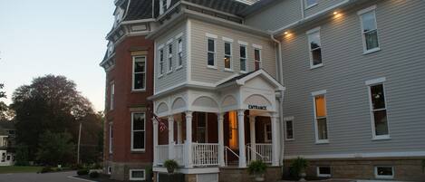 A two-story building with a prominent entrance and a covered porch area.
