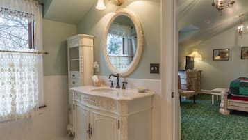 A bathroom with a white vanity, an ornate mirror, and a green carpeted floor.