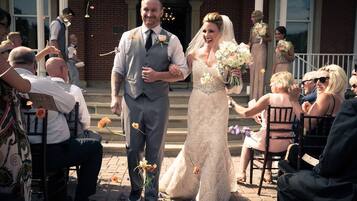 A wedding ceremony with guests seated on chairs arranged in rows.