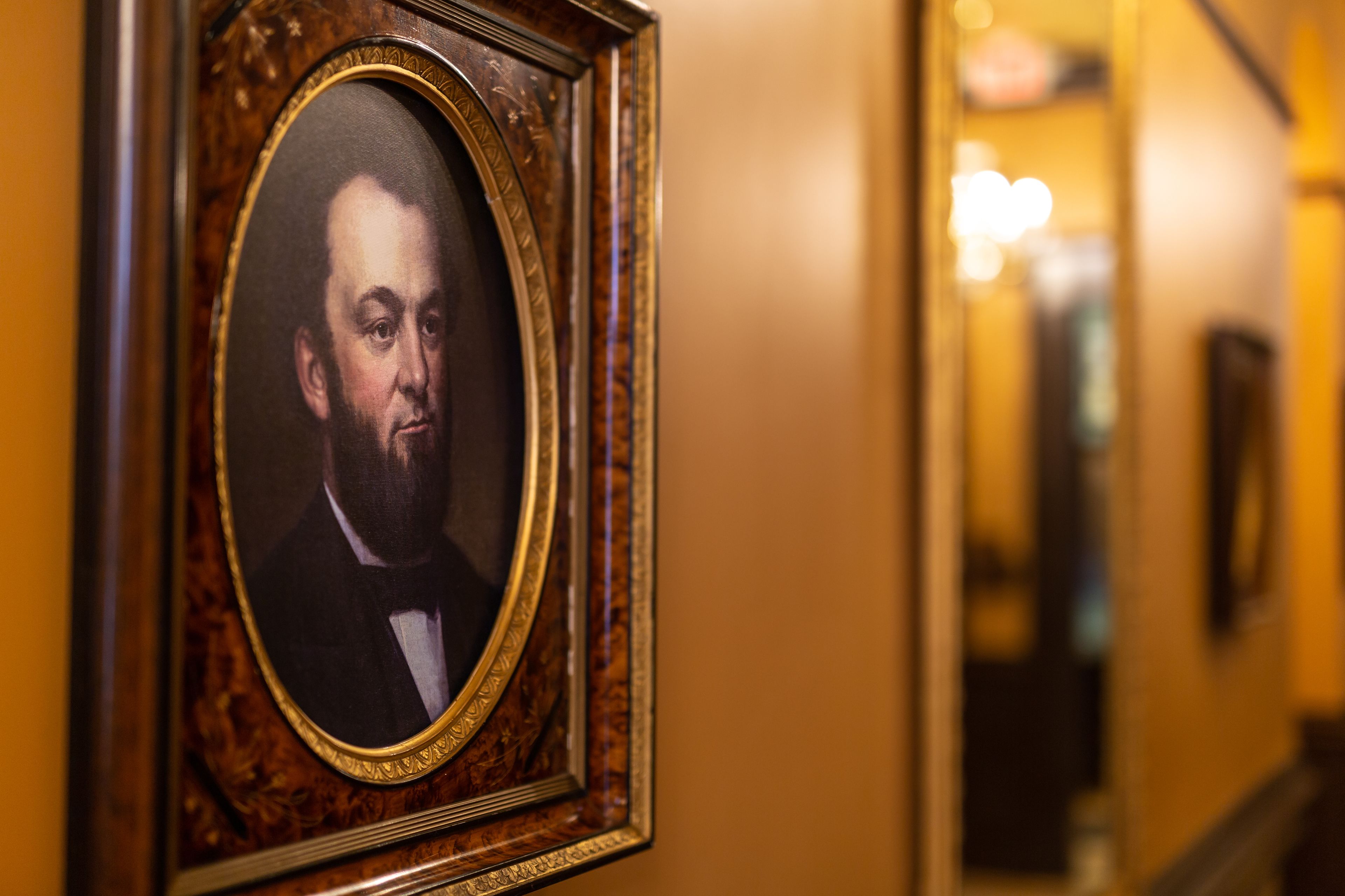 A framed portrait on a wall in a hallway.