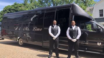 Dos hombres de pie frente a una camioneta negra con la leyenda "A-1 Mr. Limo".