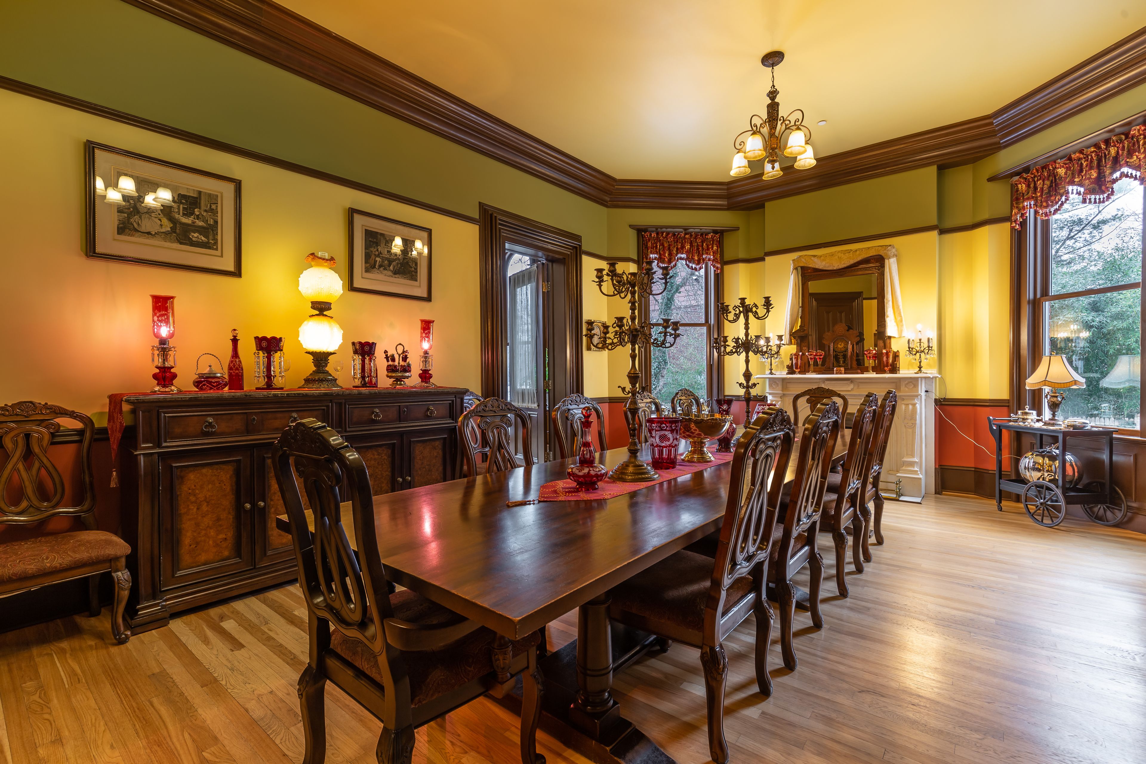 A dining room with a long wooden table, ornate chairs, and a chandelier.