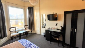A hotel room with a bed, a desk, a chair, a television, and a wardrobe. - Edinburgh Holiday Guest House (Edinburgh)