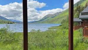 A wooden cabin with large windows overlooking a lake and mountains. - Summit Lake Lodge (Moose Pass)
