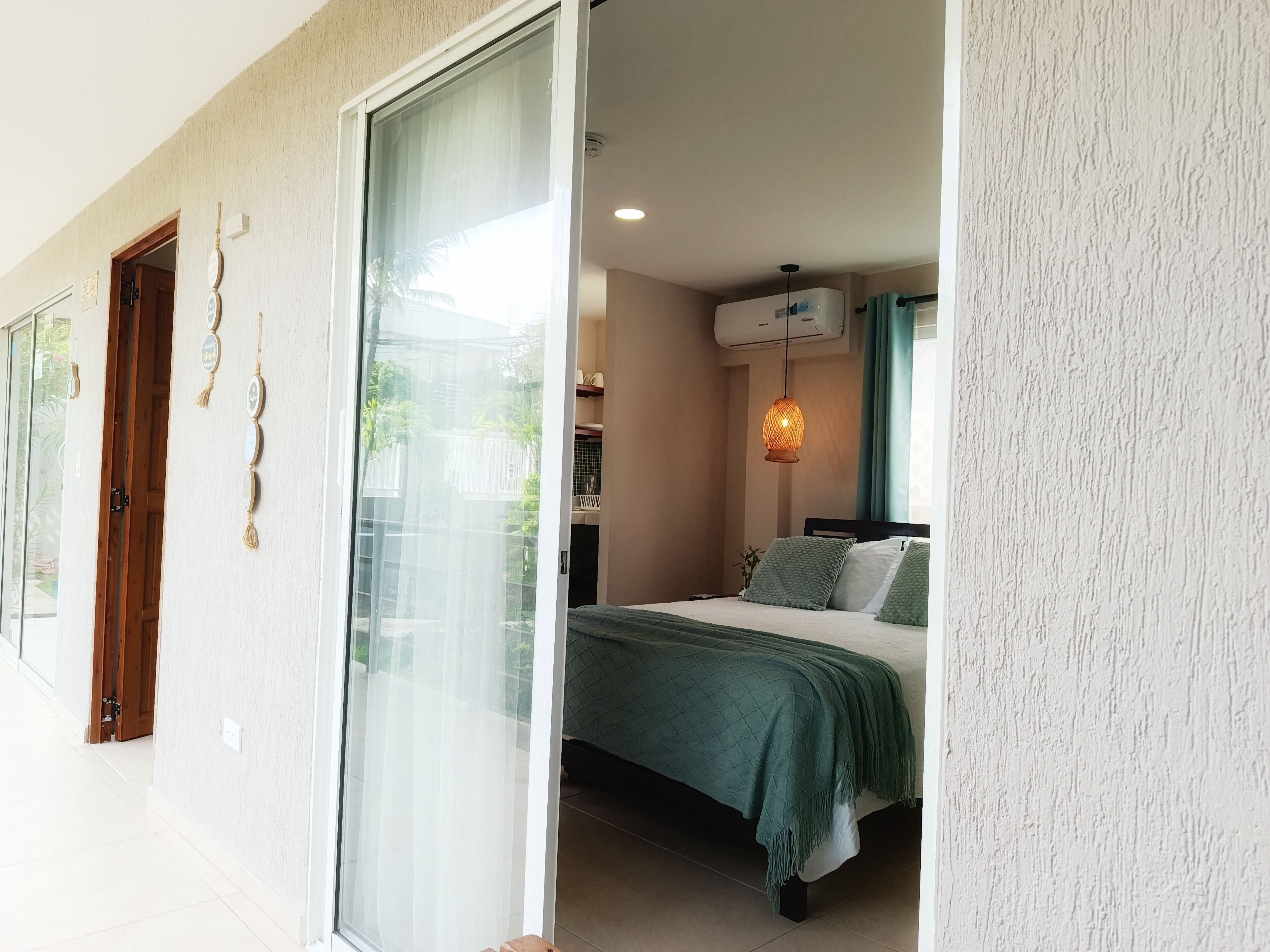 Un dormitorio con cama, ventana y ventilador de techo.