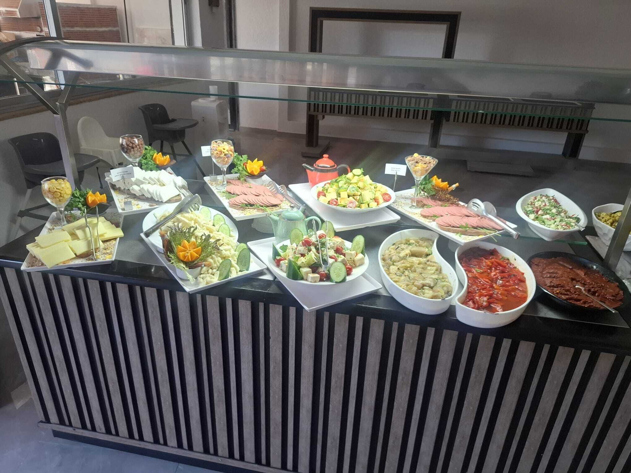 A buffet with various food items and a glass display case.