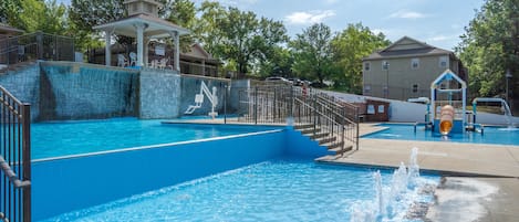 A swimming pool with a water slide, a gazebo, and a playground.