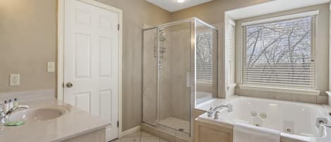 Une salle de bain avec une douche, une baignoire et un lavabo.