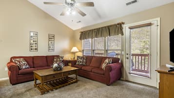 A living room with a ceiling fan, two sofas, a coffee table, and a TV stand.