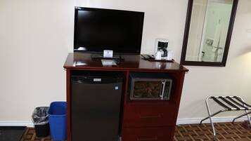 Una kitchenette compacta con refrigerador, microondas, cafetera y televisor de pantalla plana.