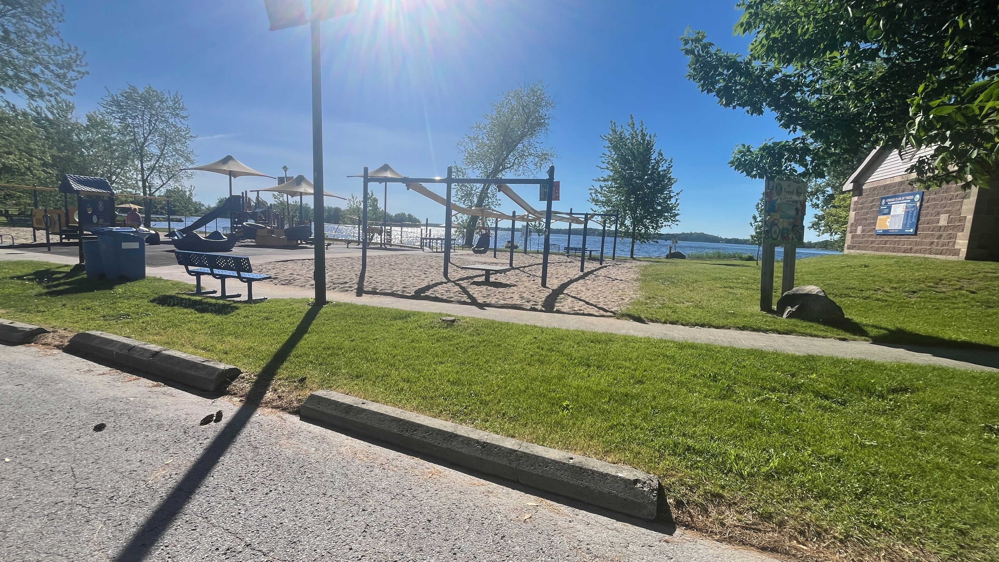 A park with exercise equipment, benches, and a clear view of the water.