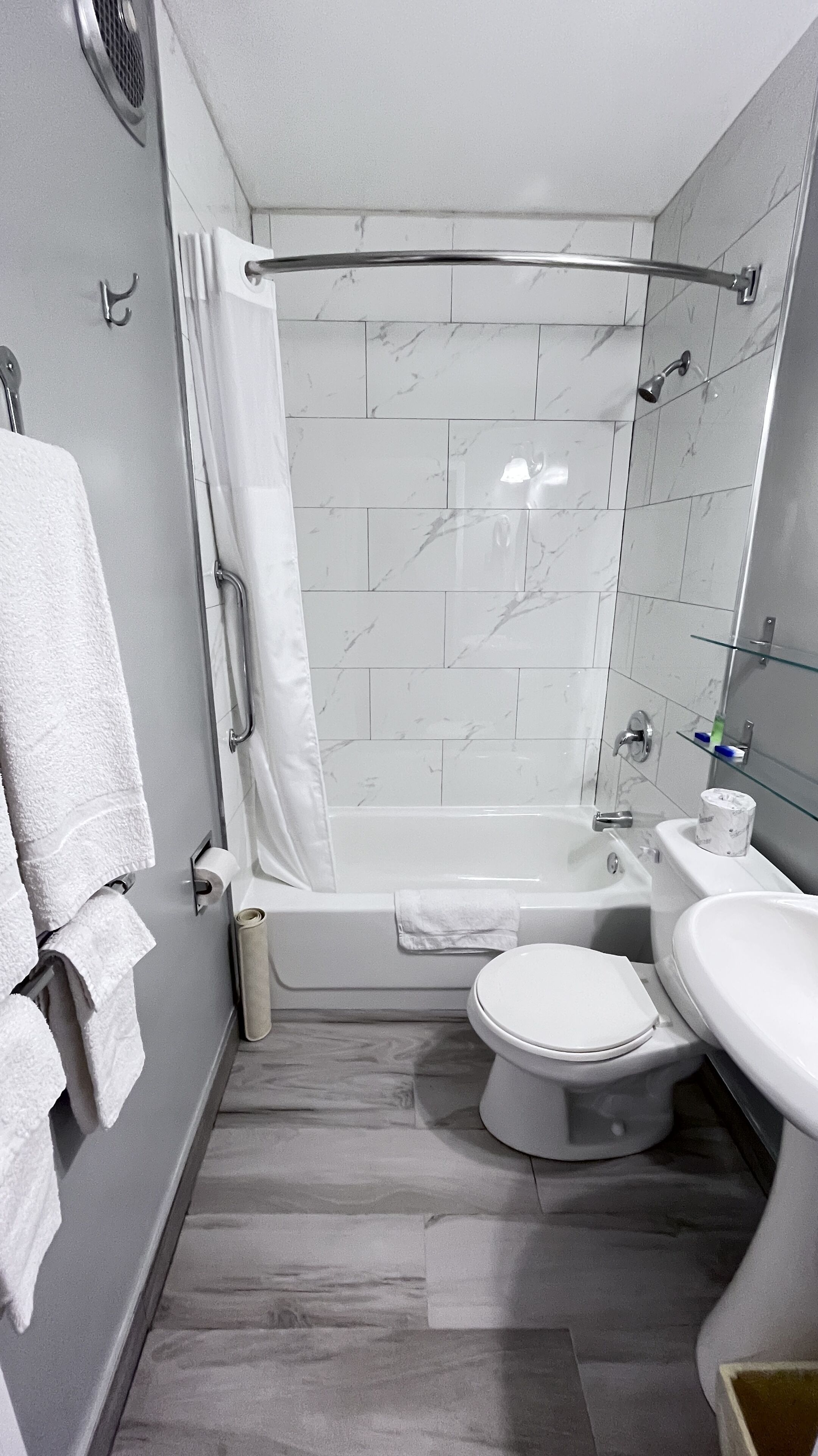 A modern bathroom with a bathtub, toilet, and sink.