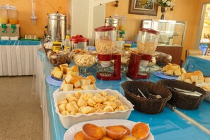 A buffet table with various food items and containers. - Hotel Guanabara (Belo Horizonte)