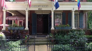 Un edificio histórico con fachada clásica, una entrada destacada y varias banderas.