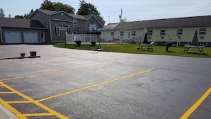 Un parking délimité par des lignes jaunes et équipé d’un panier de basketball.