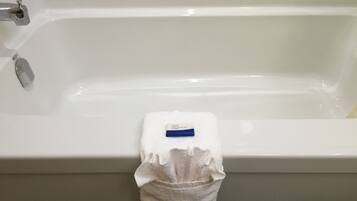 A white bathtub with a white towel hanging on the side.
