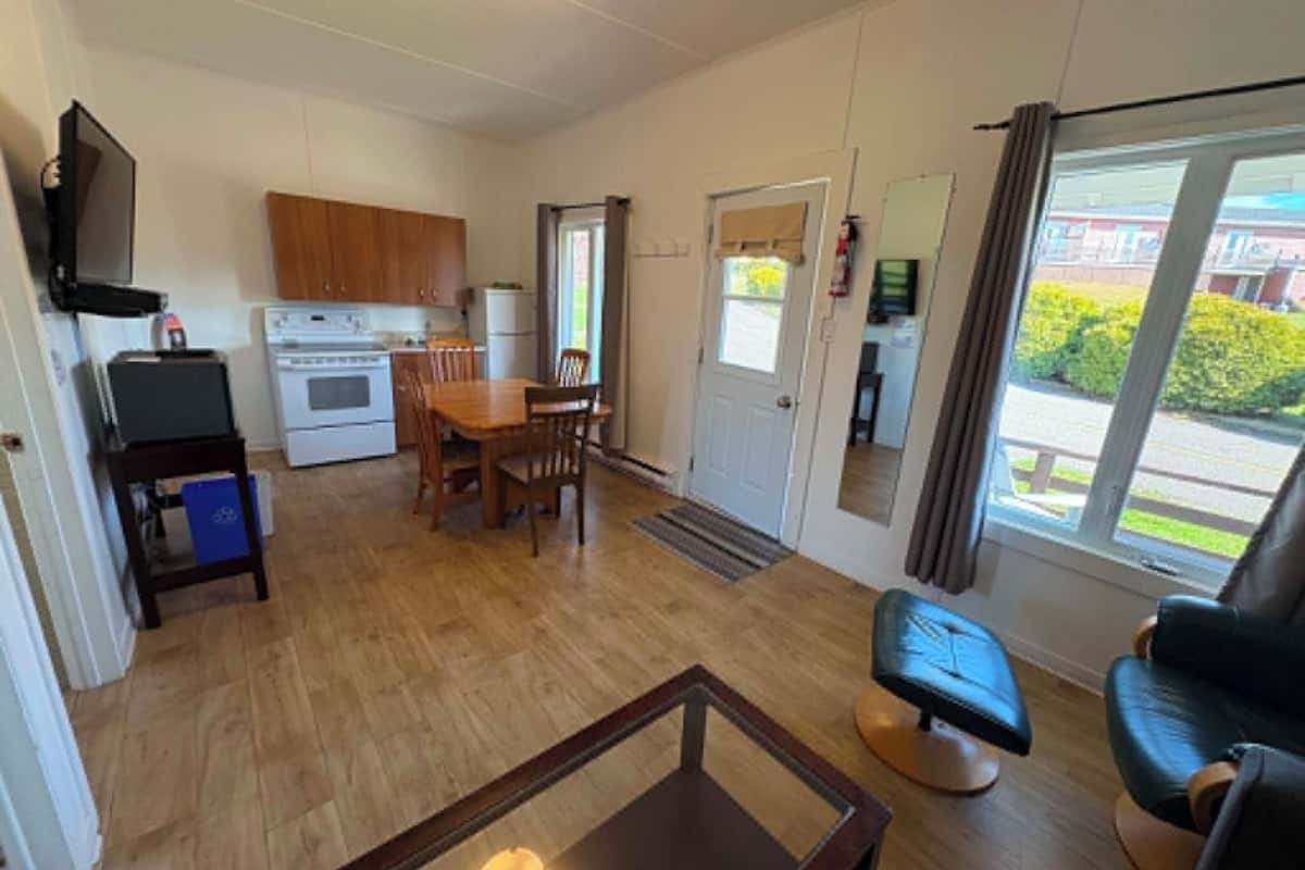 Un espacio habitable compacto con kitchenette, comedor y asientos.