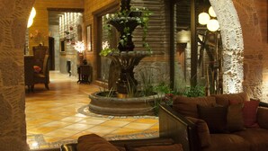 A lobby with a stone fountain, leather seating, and a brick wall. - Luxury Rancho la Loma (San Felipe)
