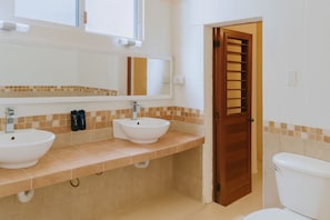 A bathroom with two sinks, a mirror, and a toilet. - Guest House La Casa del Quetzal (Mérida)