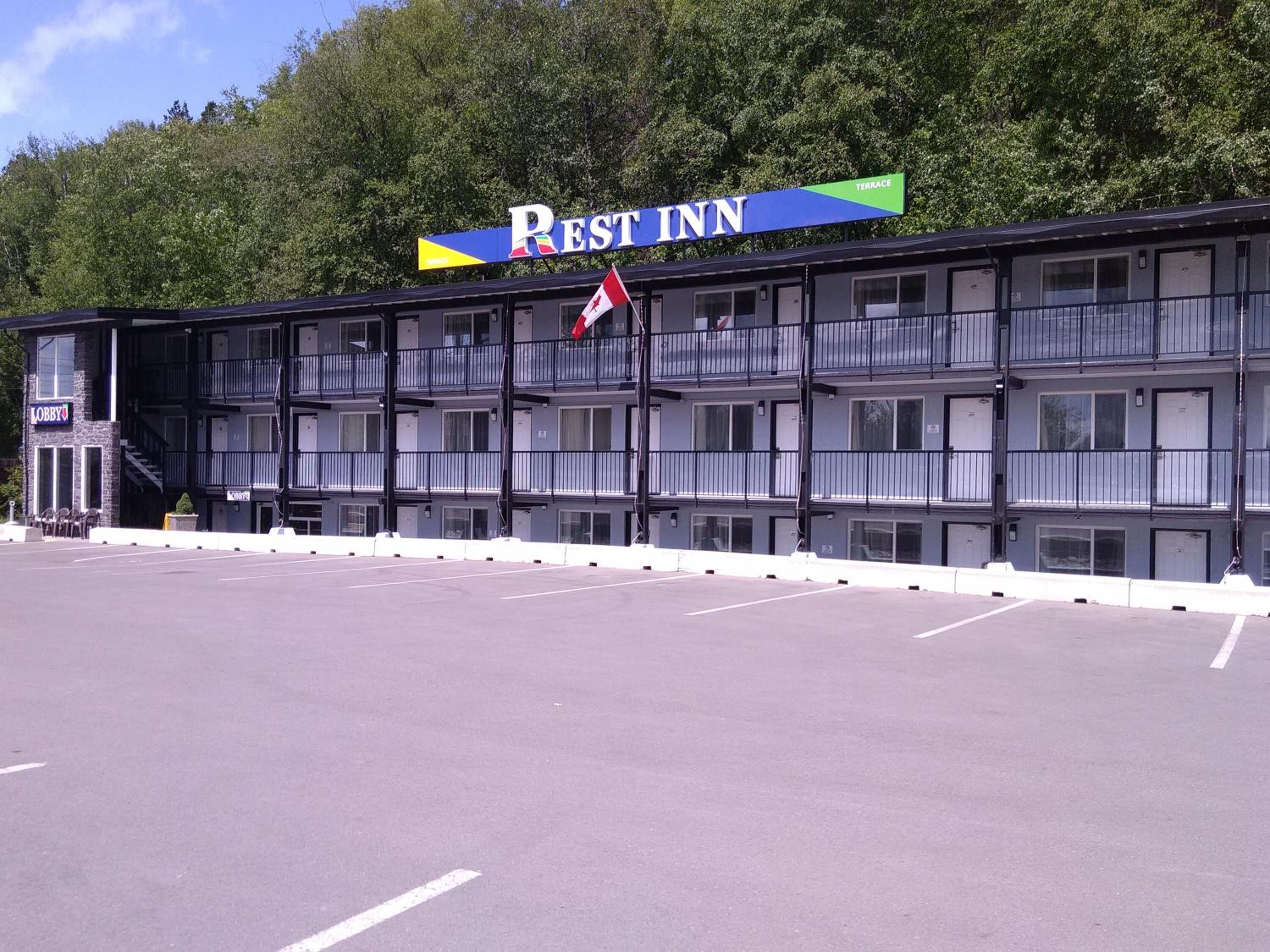 A multi-story motel with a sign reading "Rest Inn" and a flag in front.