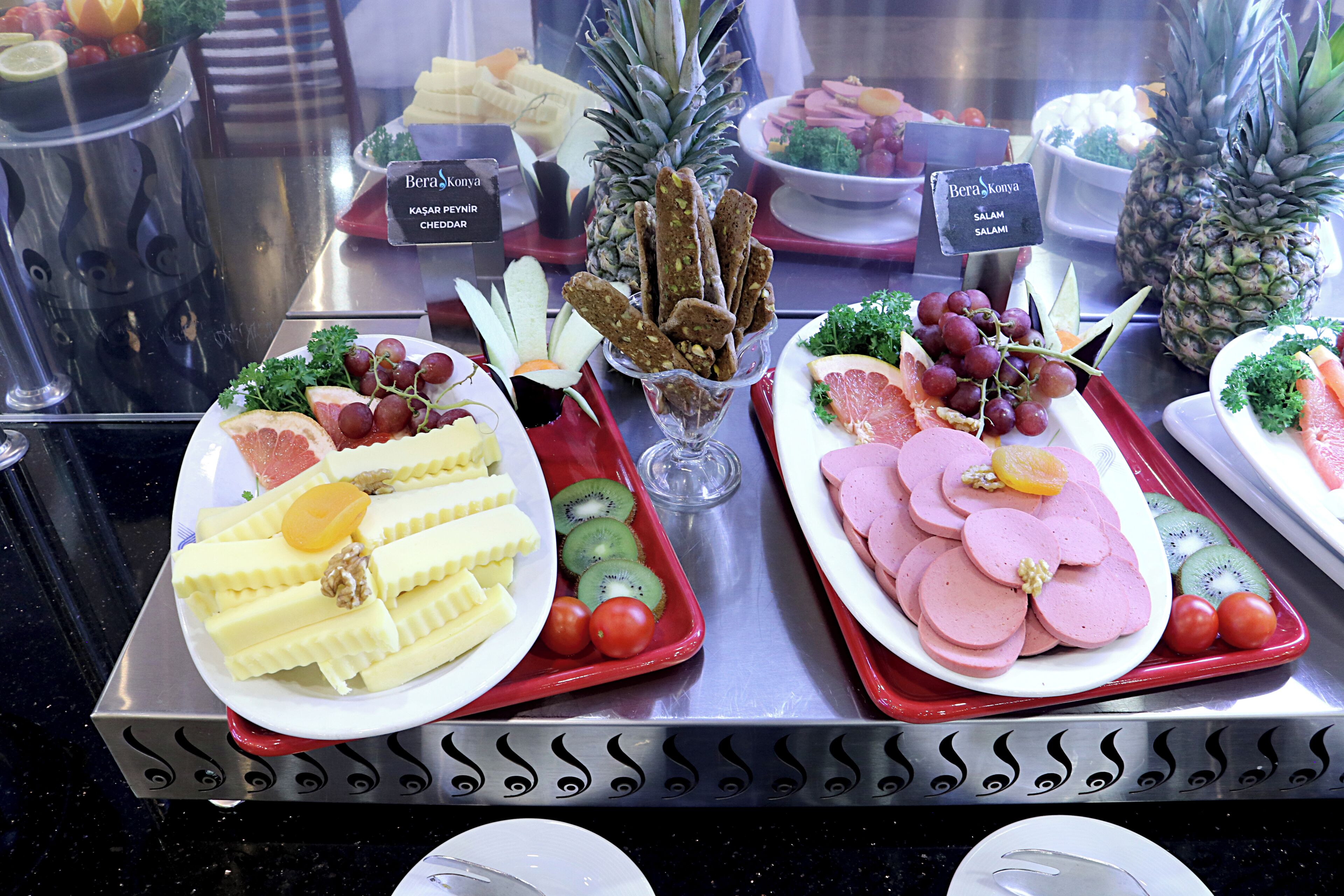 A buffet with various food items including fruits, cheeses, and meats.