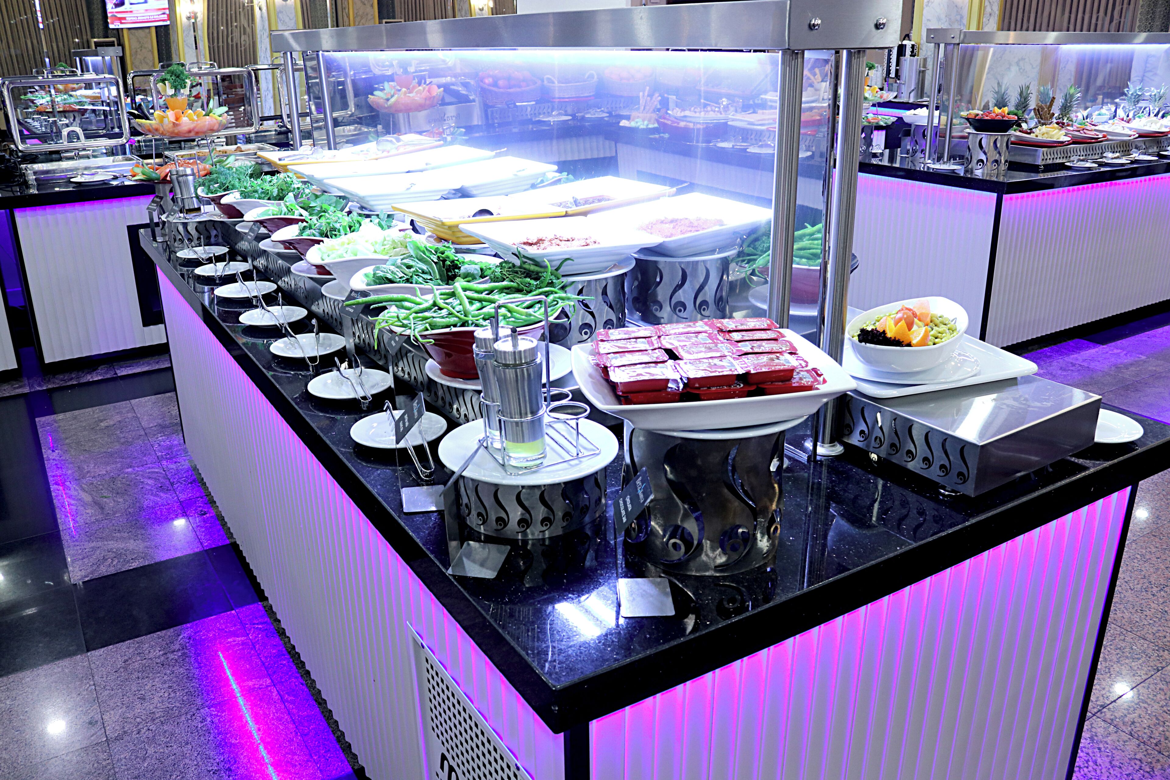 A buffet with various food items and a self-service beverage station.