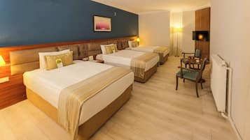 A hotel room with two beds, a chair, a TV, and a painting on the wall.