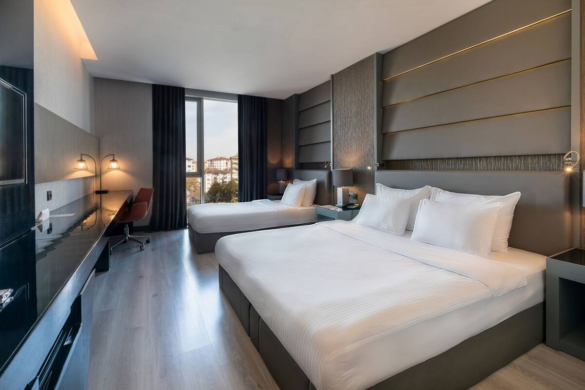 Una habitación de hotel moderna con dos camas, un escritorio y una silla.