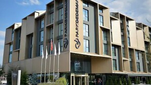 Un hotel de varios pisos con diseño moderno, que presenta un logotipo destacado en la fachada.