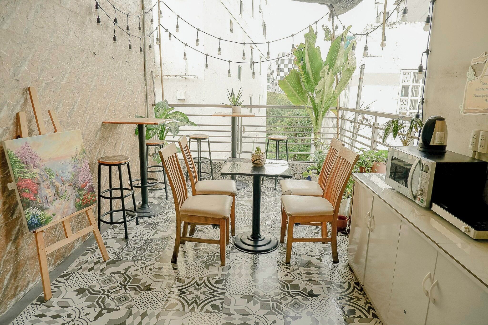 Un coin repas accueillant, avec un sol à motifs, des chaises en bois, une petite table ronde et un tableau exposé sur un chevalet.