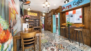 A café interior with a wooden bar, a mural, and a tiled floor.