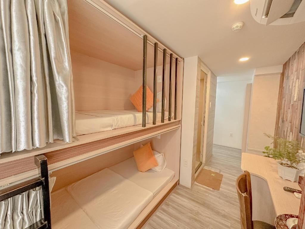 Una habitación con literas, un escritorio y una silla.