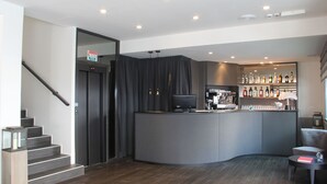 Uma área de bar moderna com um balcão curvo, uma televisão e uma seleção de garrafas de bebidas.