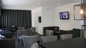 Ein modernes Wohnzimmer mit grauen Sofas, einem Couchtisch und einem flachbildfernseher an der Wand.