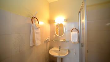 A bathroom with a sink, mirror, and towel rack.