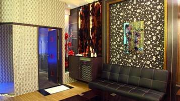 A modern room with a sofa, a cabinet, and a decorative wall.