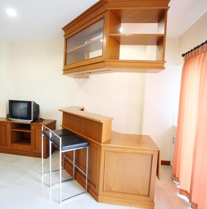 A room with a wooden desk, a television, and a chair. - Noppakao Place (Chiang Mai)