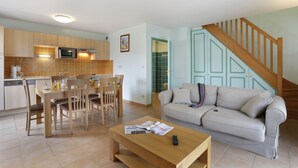 Ein modernes Wohnzimmer mit einer Couch, einem Couchtisch und einem Essbereich.