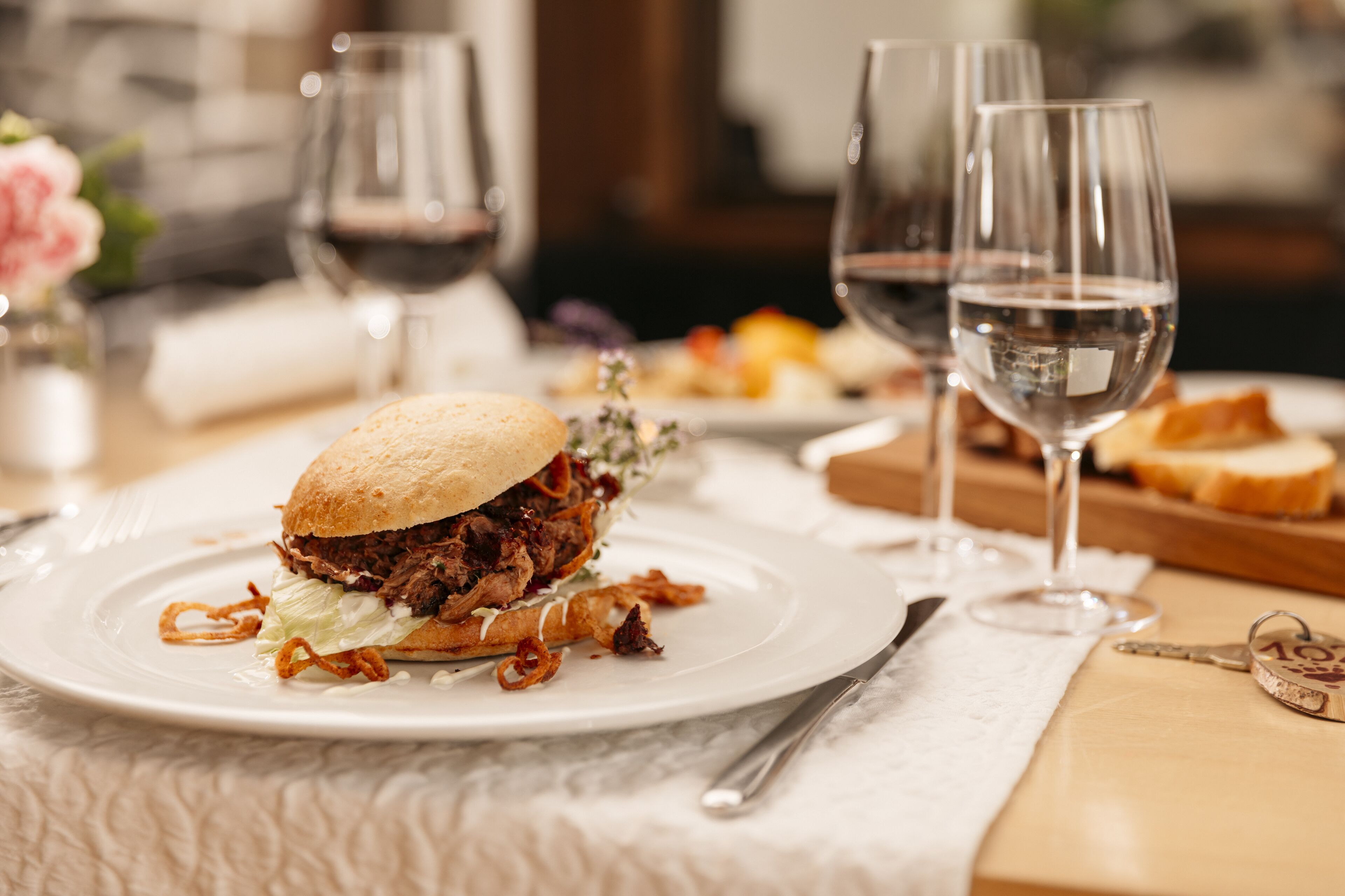 A plate with a sandwich and two glasses of water on a table.